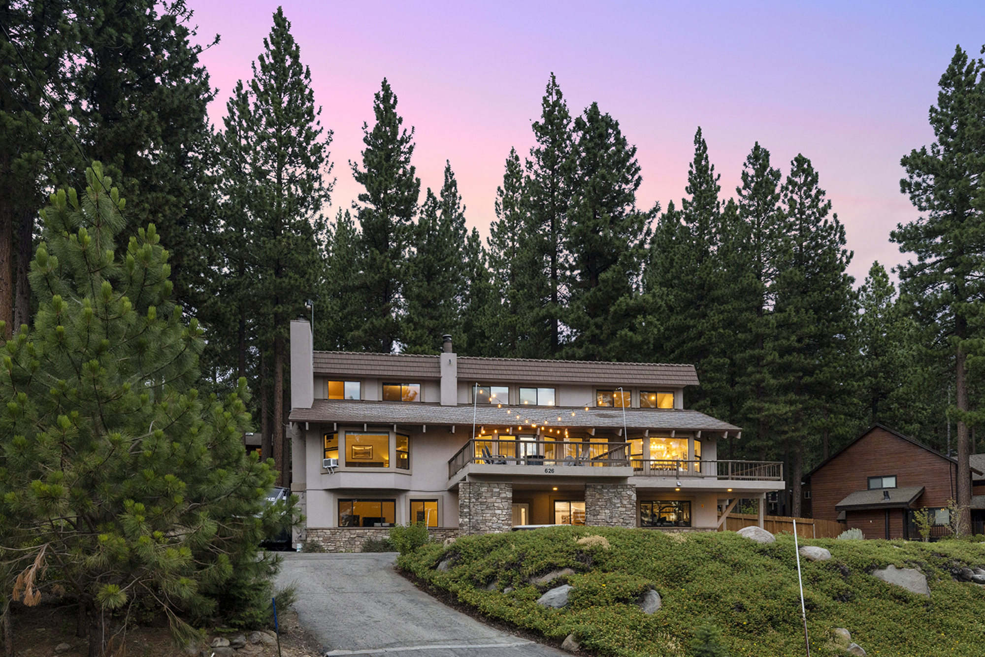 Kinpine House deck and exterior at dusk with lit windows