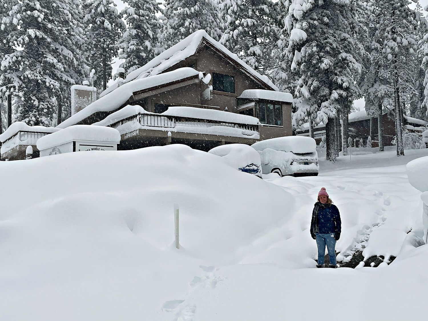 Kinpine House buried in fresh snow, cars covered in the driveway during a Tahoe storm